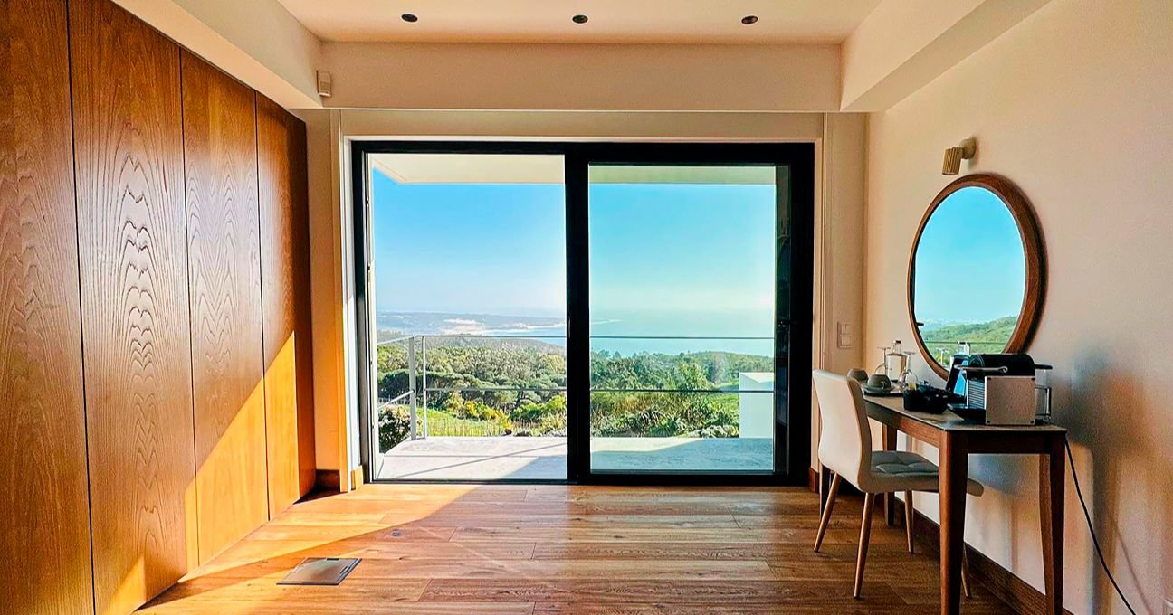 Elegant room with a dressing table and a large panoramic window in the Panorama Residence at Quinta Vale da Roca.