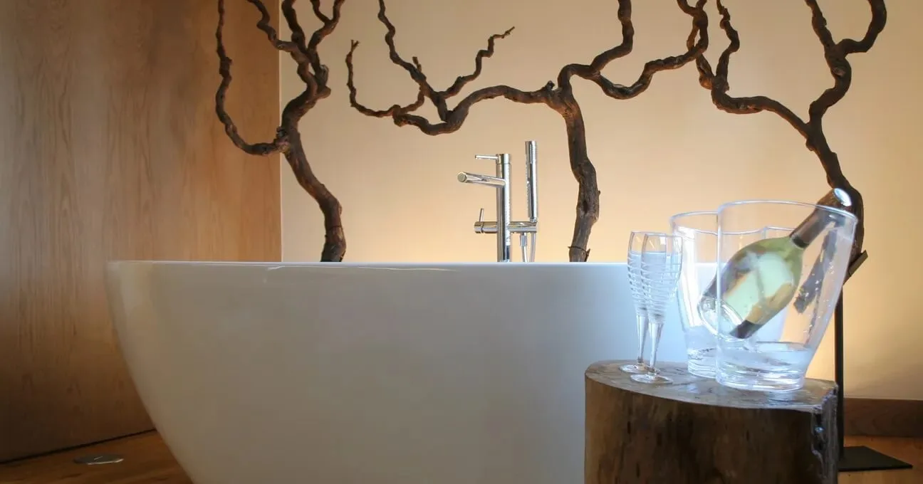 Spacious bathtub in the bedroom and served white wine