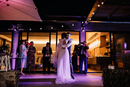 Bride and groom sharing their first dance during an intimate vineyard wedding at the evening