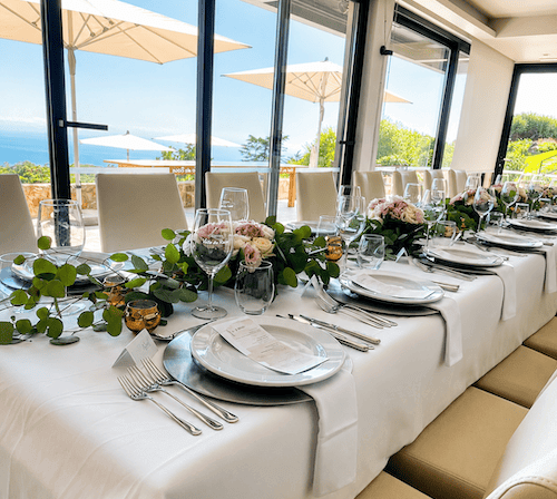 Indoor wedding dinner table decorated with candles and fresh flowers