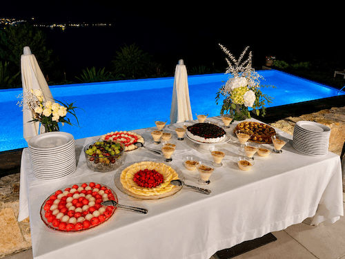 Wedding table served with fresh food and snacks near the swimming pool