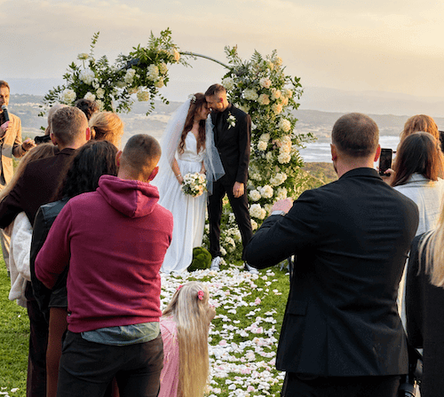 Wedding guests applauding the newlyweds after an outdoor ceremony