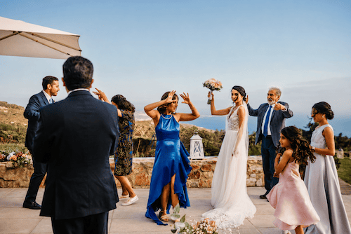 Guests dancing with bride at an elegant wedding on the ocean-view terrace