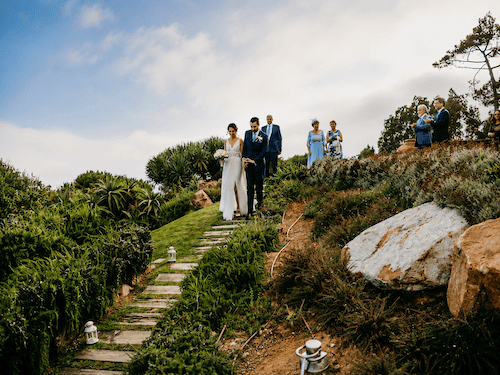 Bride and groom walking down the aisle surrounded by vineyards