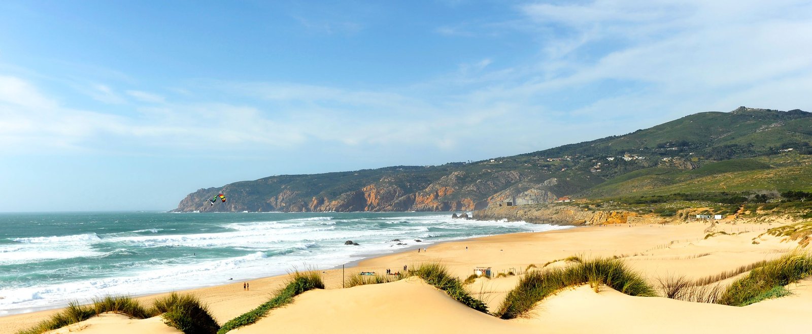 Praia do Guincho beach with golden sand dunes and Atlantic Ocean waves near Cascais, Portugal